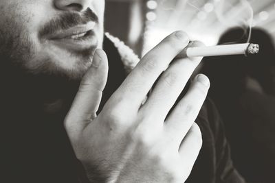 Close-up of man holding cigarette