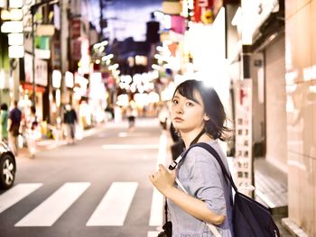 Young woman standing on street in city