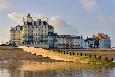 Victorian hotel on the seafront in eastbourne. a  light sky with an empty beach in the foreground.