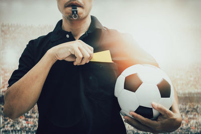 Low angle view of man holding ball on beach