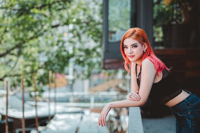 Portrait of confident woman standing in balcony