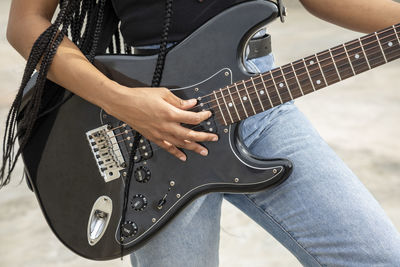 Midsection of man playing guitar