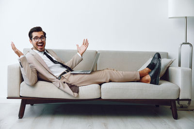 Portrait of young man sitting on sofa at home