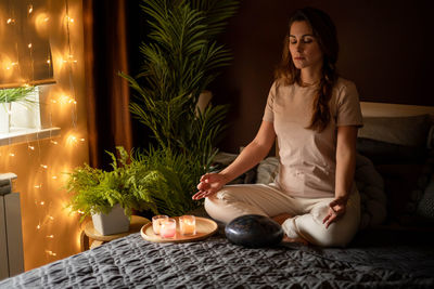 Full length of woman meditating at home