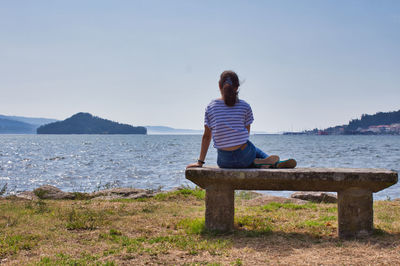 Gils sitting on a bench a looking at tambo island in poio