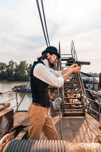 Man standing on boat against sky