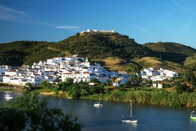 High angle view of houses by sea against sky