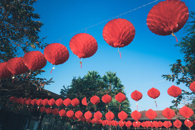 Low angle view of lanterns hanging against sky