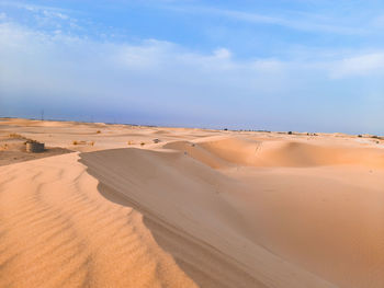 Sand dunes in desert against sky