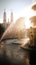 Water splashing fountain against sky