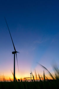 Low angle view of silhouette windmill against sky at sunset
