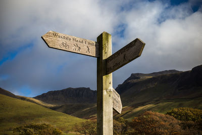 Cross sign on mountain against sky