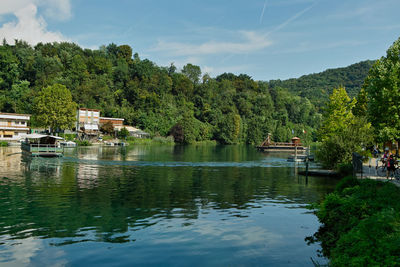Scenic view of lake by trees against sky