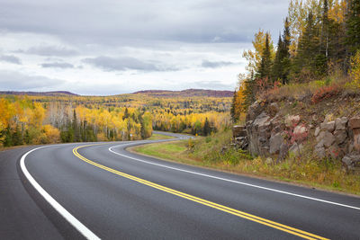 Road amidst trees against sky