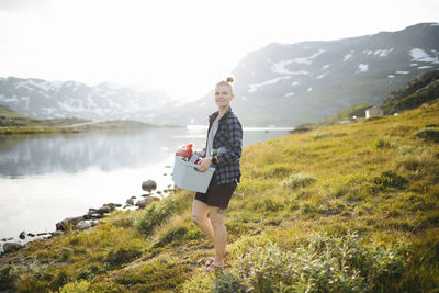 Woman sitting at lake in mountains