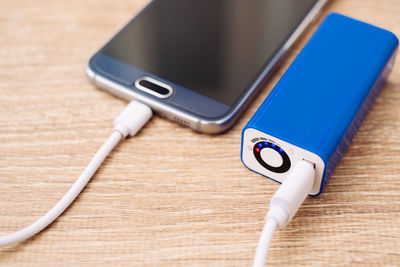 High angle view of charging smart phone on table