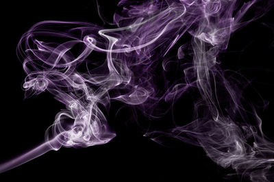 Purple smoke against black background