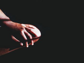 Close-up of hand touching black background