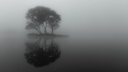 Scenic view of lake against sky during foggy weather