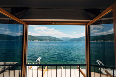 View of sea against sky seen through window