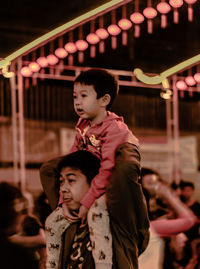 Full length of mother and daughter looking at illuminated camera