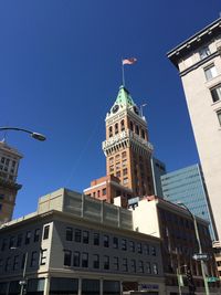 Low angle view of clock tower against blue sky