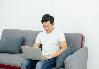 Man using mobile phone while sitting on sofa