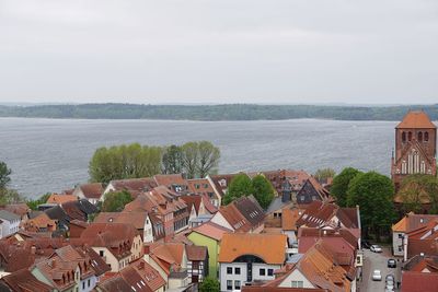 High angle view of townscape by sea against sky