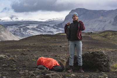 Backpacker layering up to avoid storm in iceland highlands