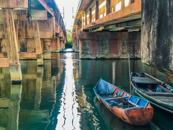 Boats moored in canal along buildings