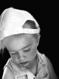 Close-up portrait of cute boy against black background