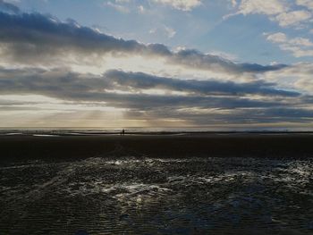 Scenic view of calm sea against cloudy sky