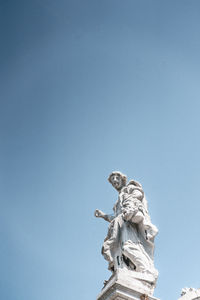 Low angle view of statue against blue sky