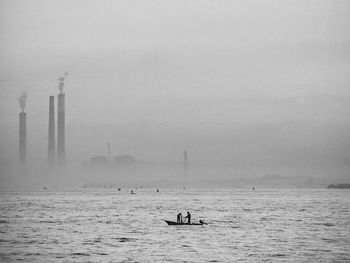 People on sea against sky