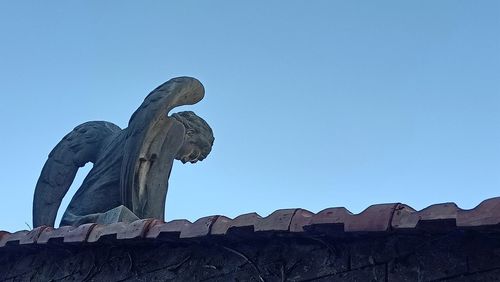 Low angle view of statue against blue sky