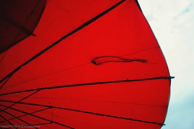 Low angle view of red umbrella against the sky