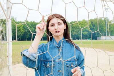Portrait of young woman looking through net