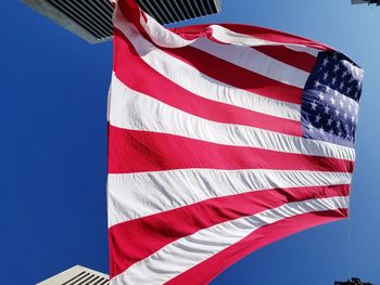 Low angle view of flag against blue sky