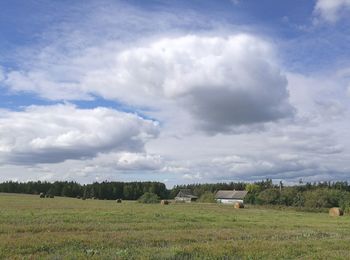 Scenic view of grassy field against cloudy sky