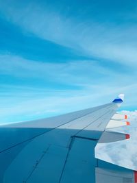 Airplane flying in sky seen through glass window