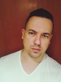 Close-up portrait of young man against wall