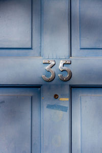 House number 35 on a light blue wooden front door in london 