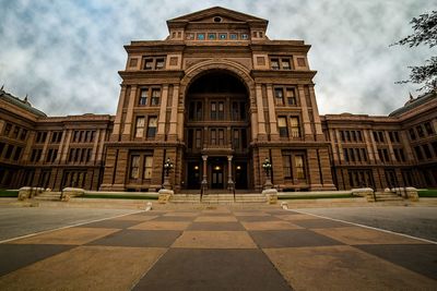 Low angle view of texas state capitol against cloudy sky