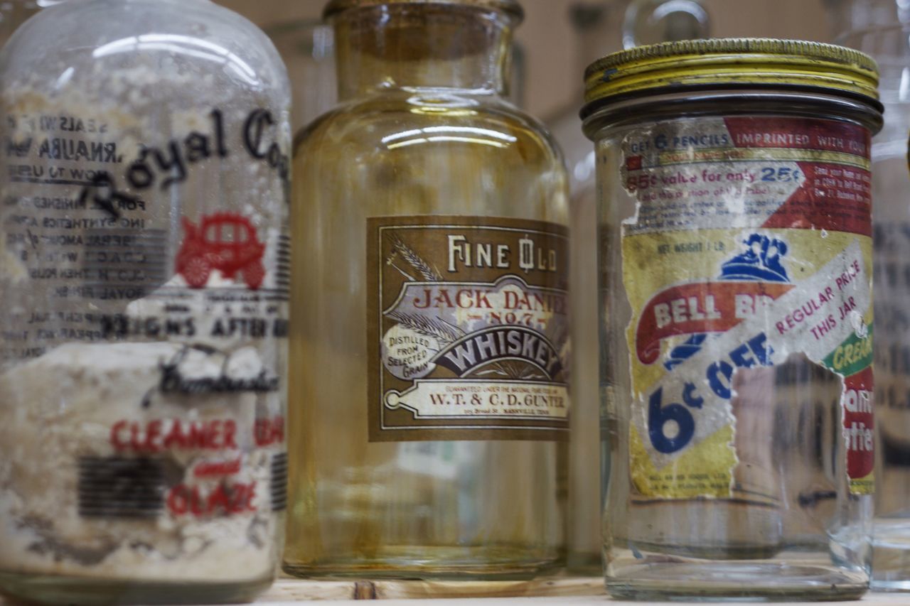 CLOSE-UP OF TEXT IN JAR ON GLASS