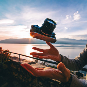 Cropped image of hands catching falling camera