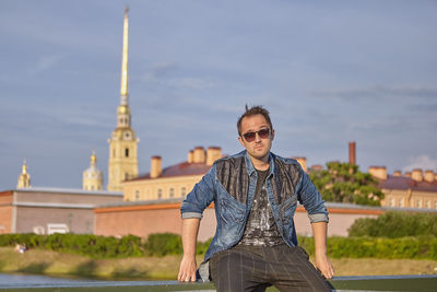 Portrait of mature man standing against built structure