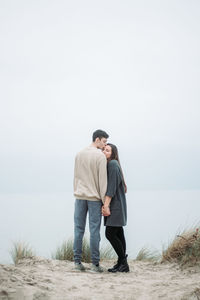 Full length of couple standing against clear sky