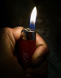 Close-up of hand holding candle