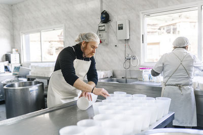 Mature chef couple working in dairy factory