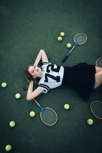 High angle view of tired young woman lying on court